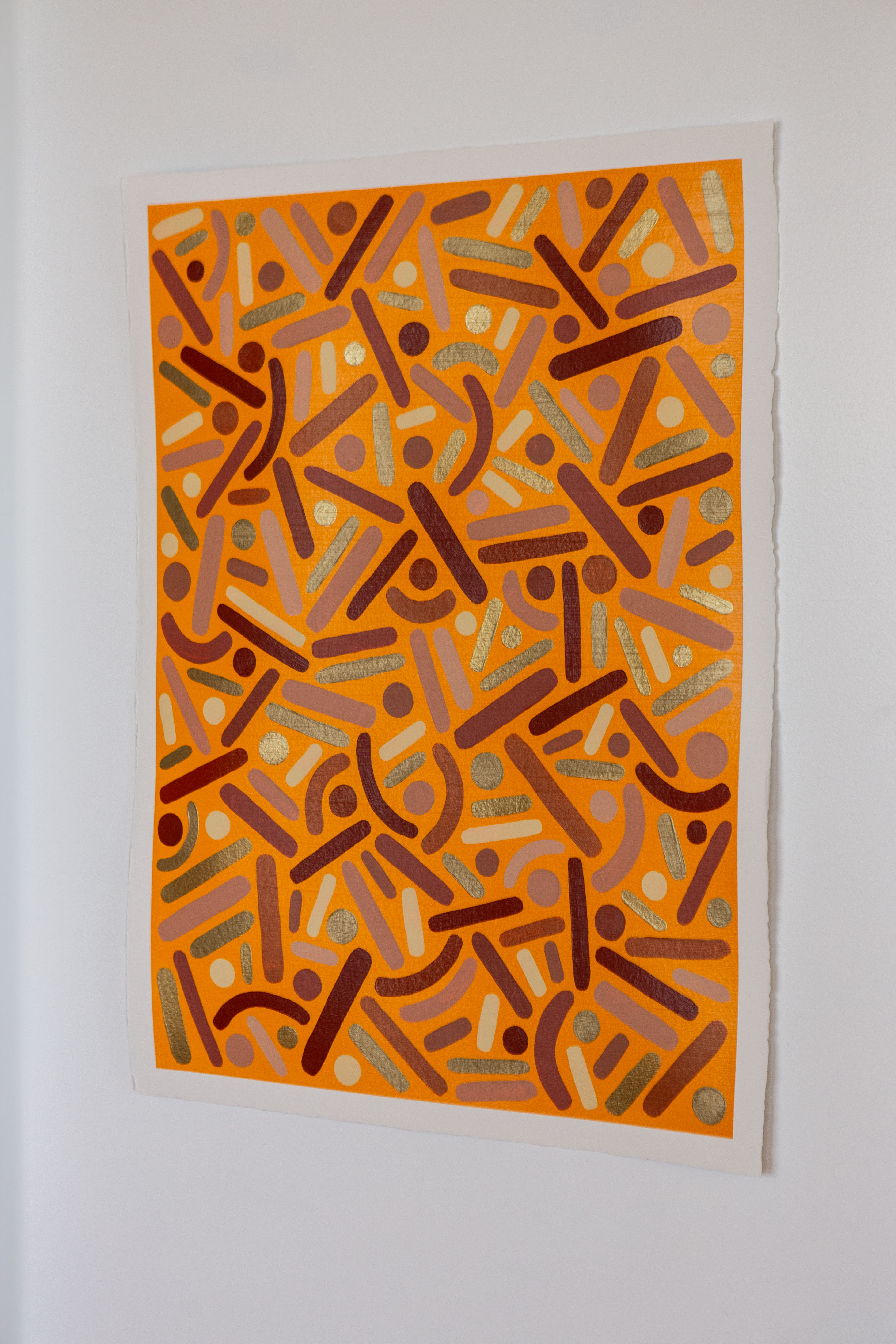 Canyon Frequency: Orange dots-and-curves artwork hanging on a pale wall.