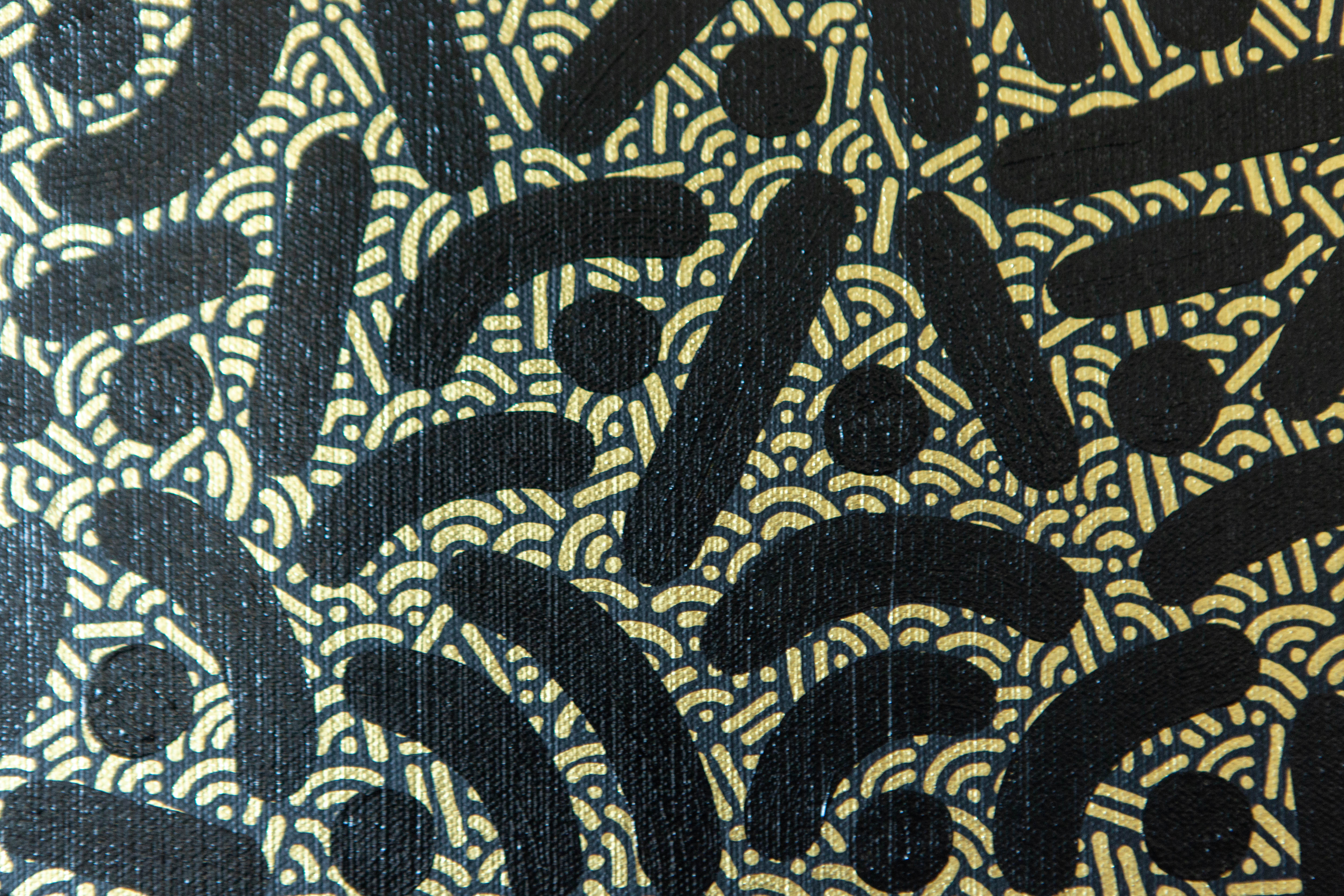 Close-up of Nexus by Pipe Yanguas, showing layered gold patterns of dots and lines between bold black strokes.